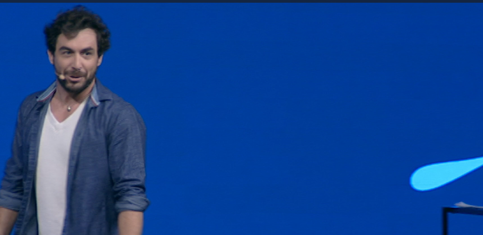 Julien Lopez en conférence sur scène, fond bleu